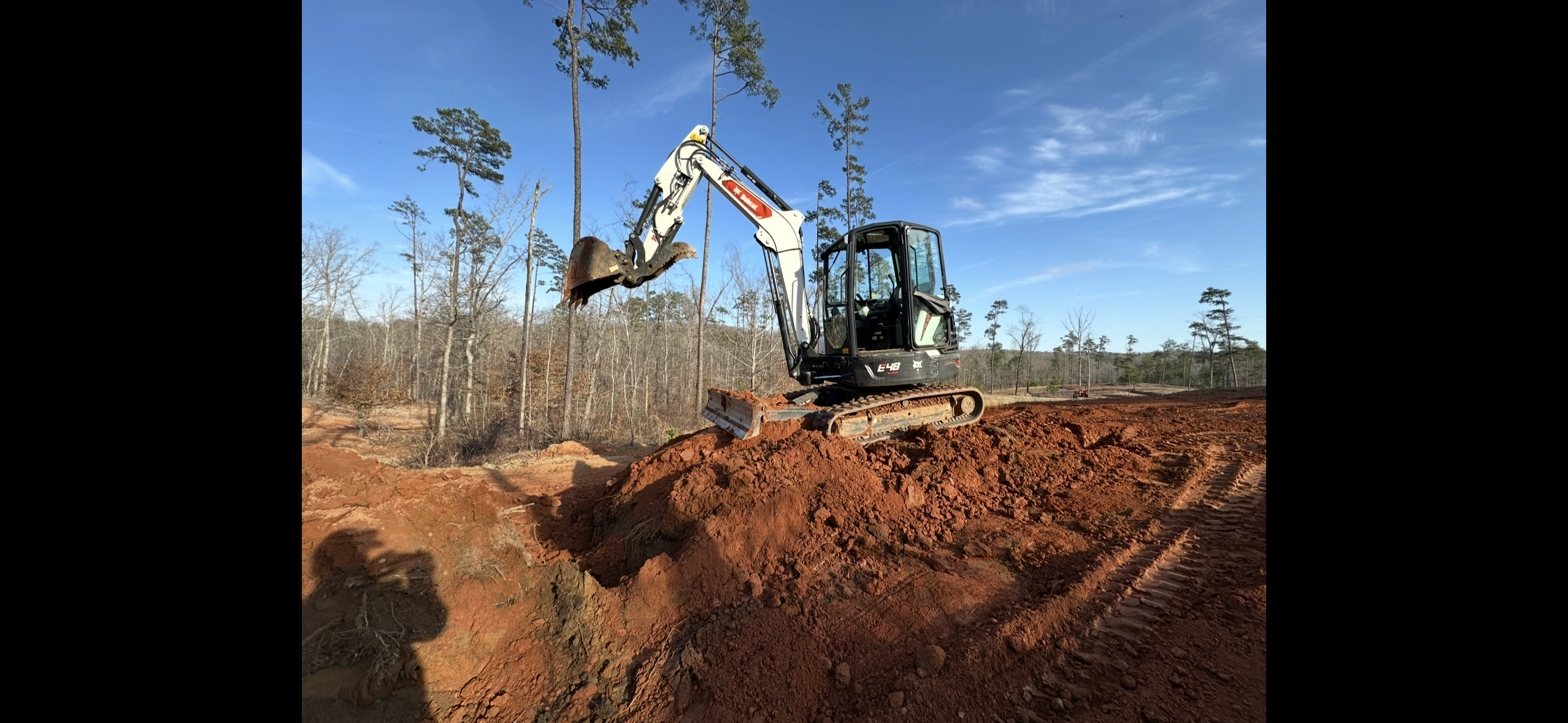 Bobcat E48 excavator grading a site
